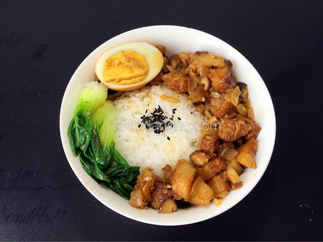 米饭提前煮好，稍微大一点的碗装饭，上面撒点黑芝麻装饰，煮好的卤肉码上，放一点烫好的青菜和半个卤蛋，一碗卤肉饭就可以吃了。