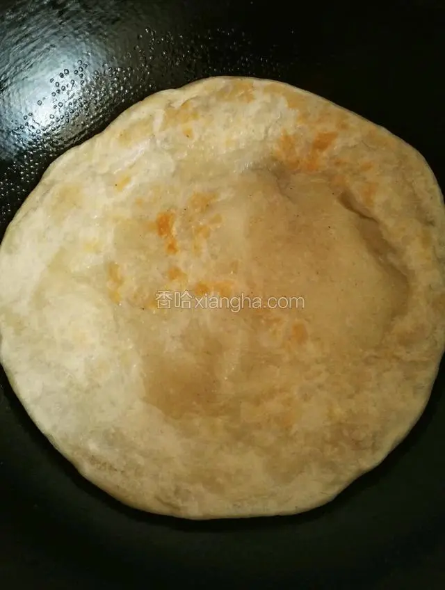 把大饼放入锅内小火至两面微黄盖上盖这时大饼内部鼓起大包说明里面已经熟了
