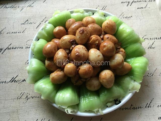 炒好的鹌鹑蛋盛入装有大油菜的盘子