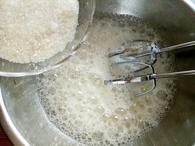 蛋白中滴入几滴柠檬汁，打发至粗泡，加入三分之一白糖。