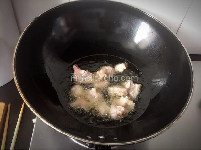 待油温升起时，倒入腌制好的排骨，小火慢炸