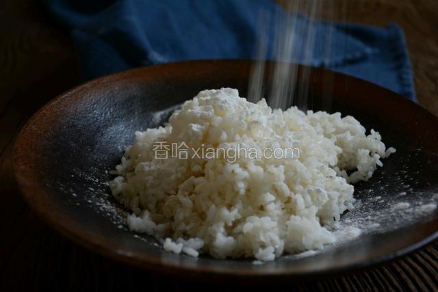 米饭要用隔夜饭，撒上适量的生粉将米饭拌成粒状。