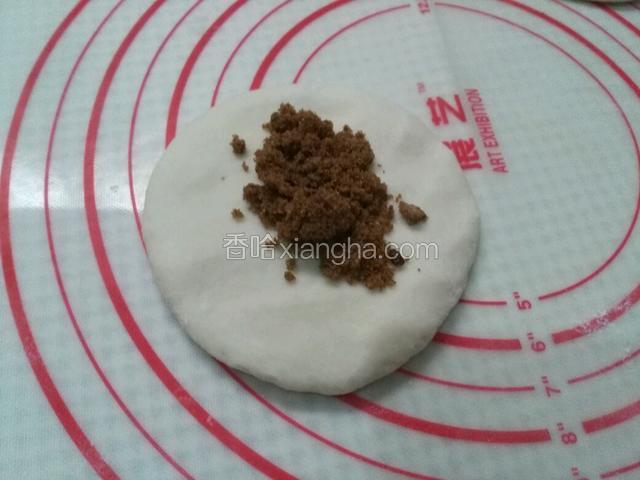 取一个面皮放上红糖，糖的多少自己随意，注意面皮上别撒面粉，有面粉不容易沾，