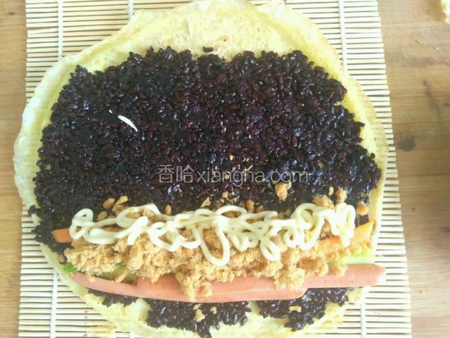 将煎好的胡萝卜，黄瓜，火腿肠放在铺满米饭的一头，还要撒上肉松，挤上沙拉酱。