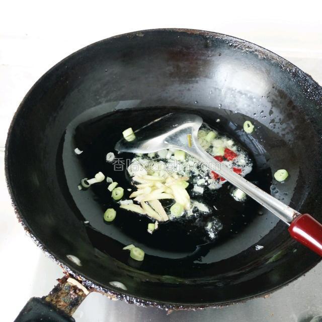 热油，加入适量红辣椒、葱和姜爆香