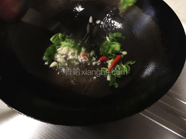 锅烧热，放入适量玉米油。倒入青辣椒、红辣椒、蒜瓣。