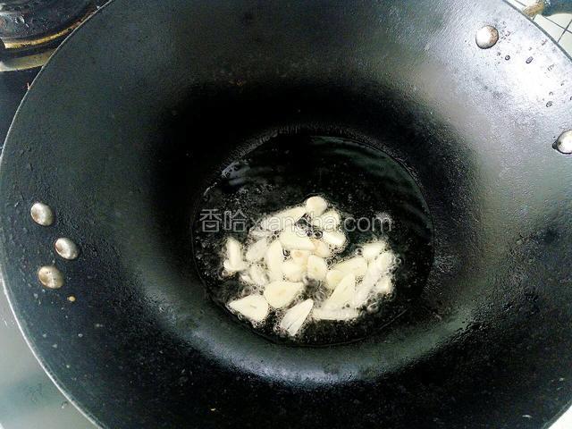 锅热油后放入蒜片煸出香味