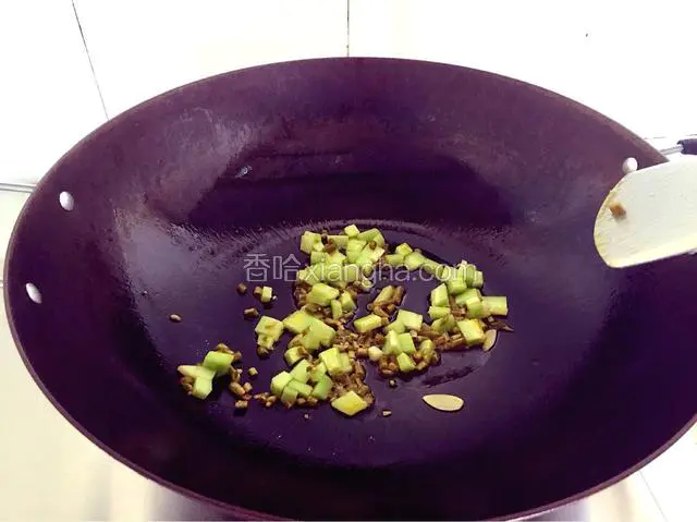 将炒散的米饭装盘备用，重新倒油，油烧七成热，倒泡豇豆和黄瓜。（不小心倒入了一片蒜片）