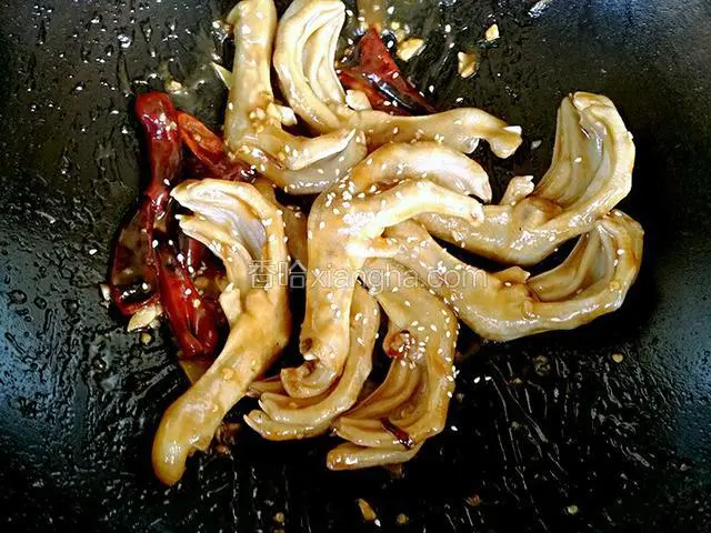 再把白芝麻撒入锅内，炒均出锅装盘，再撒上葱花做点缀，这道“香辣鸭掌”就成了。这道菜装盘之后是看不到辣椒和部分调料的，这样做的目的是让菜看起来更美观些