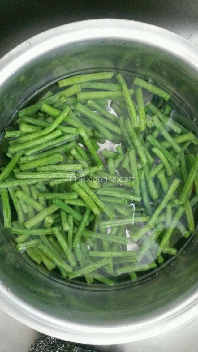用开水把豇豆焯一下，水中放少许盐。