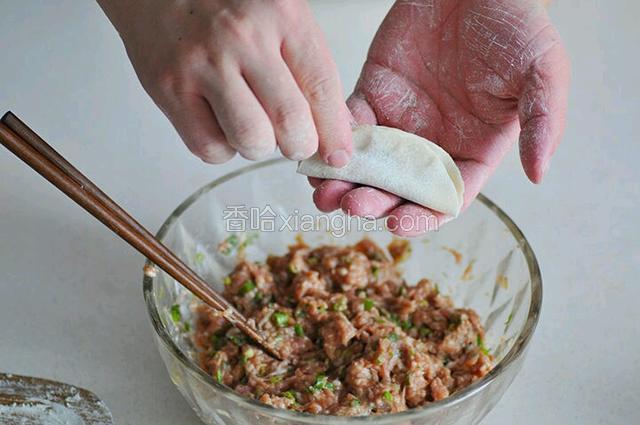 取一张饺子皮，放适量肉馅包好～