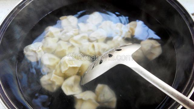 锅里水烧开放入饺子，用笊篱推动，以防粘连