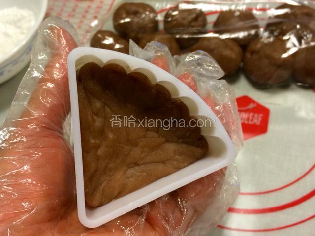 沾上手粉，放进冰皮月饼模中压制成型；