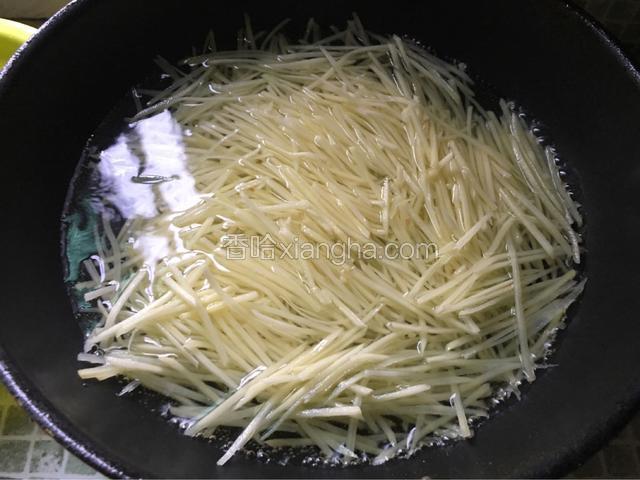锅中放入适量水烧开后把土豆丝放去焯一分钟然后捞出