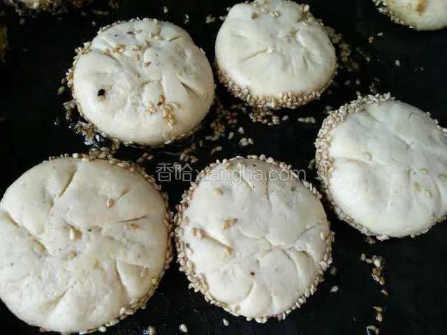 饼铛放油烧热，芝麻一面朝下，煎制到芝麻发黄