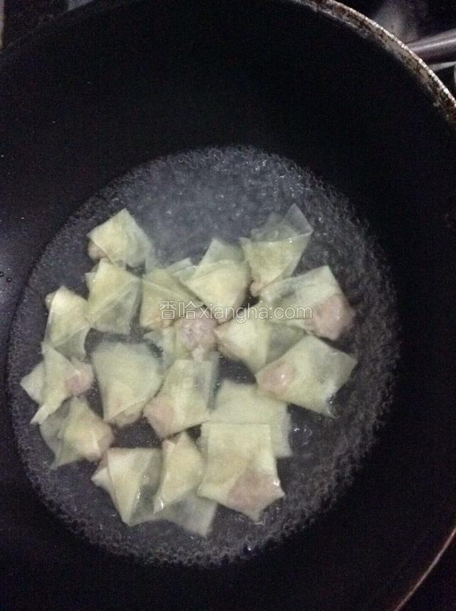 锅中注入清水烧开，下入包好的馄饨。