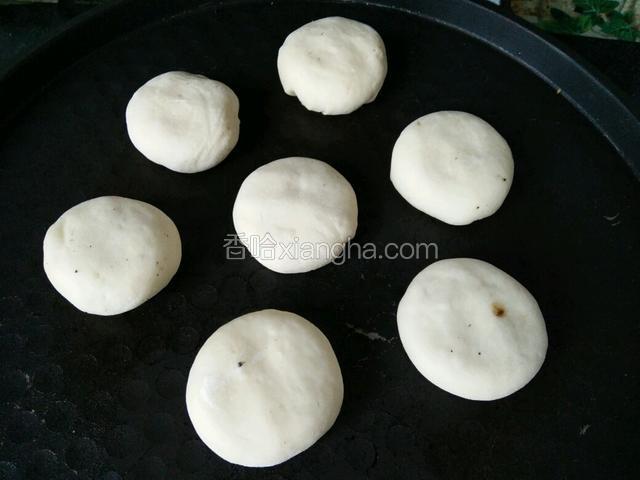 电饼铛预热，将包好的饼一个个放进电饼铛里按扁。