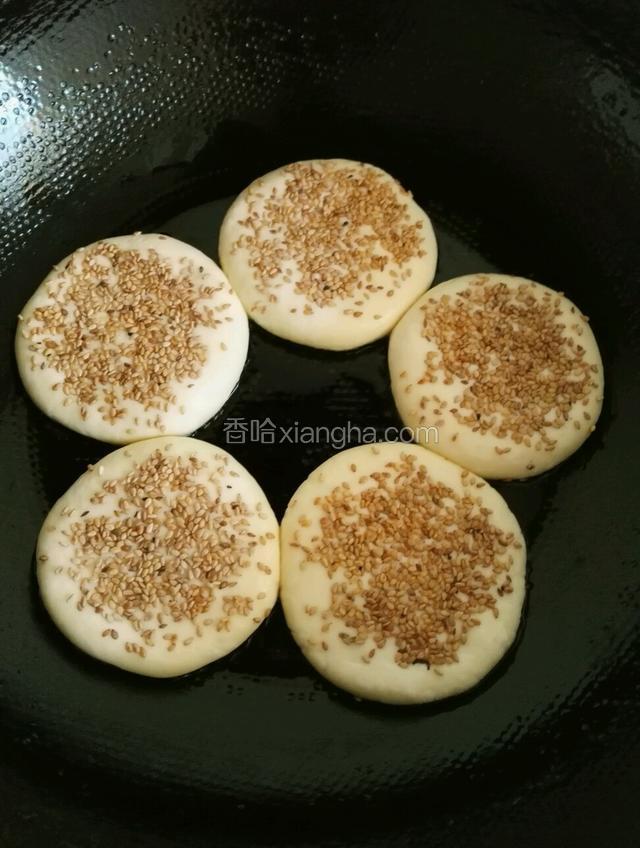 平底锅小火烧热，抹一层油放入烧饼胚