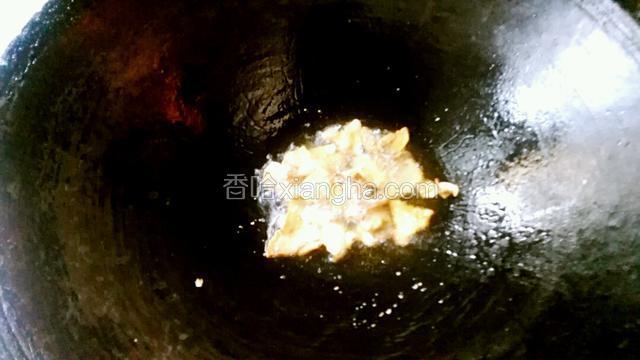 热锅下肥肉煎炒出油，加点料酒炒至金黄色。