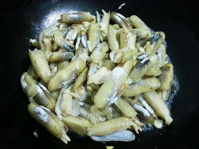 然后放入蛏子翻炒，加入少许盐和料酒翻炒