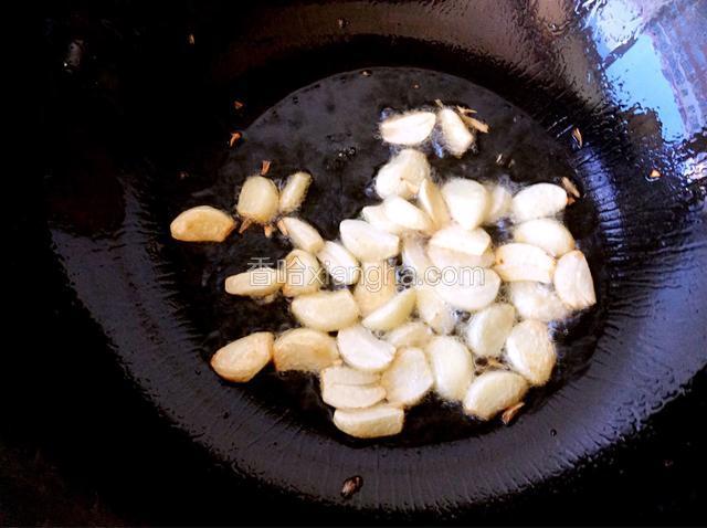 锅中加油烧热，倒入大蒜炒出香味并至金黄色