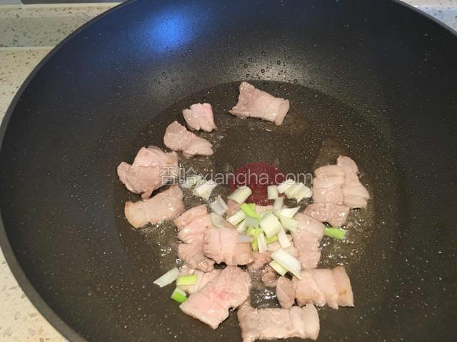 热锅凉油，油温升高后放入肉片翻炒。肉片炒变色后，放入葱花炒出香味。