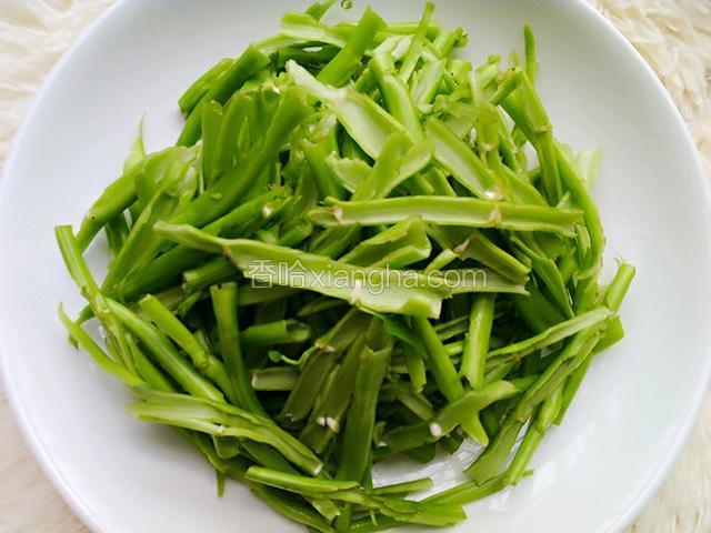 在把菜梗用手撕破，掐成节，