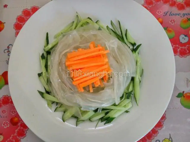 胡萝卜切细丝，均匀摆放在拉皮上面