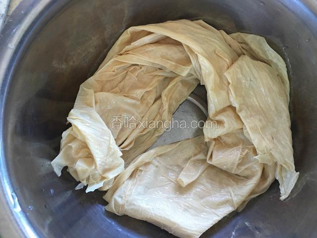 泡好的豆油皮清洗一下，攥干水份。