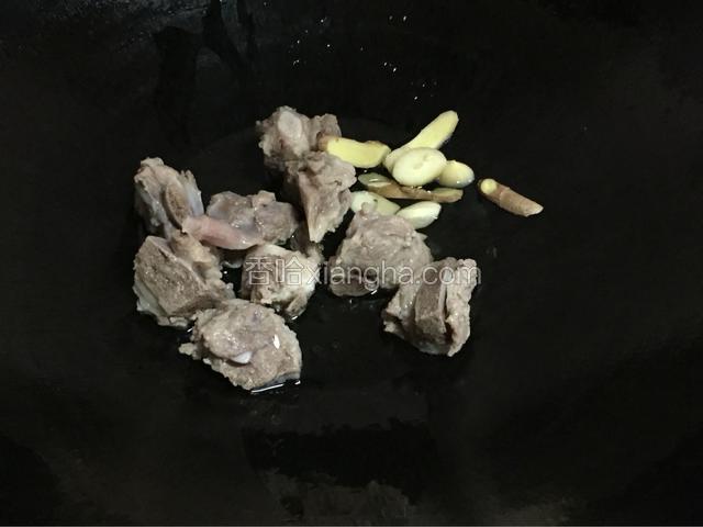 锅里烧油，倒入姜蒜爆香，倒入排骨翻炒到两面金黄