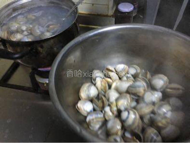 撇去水上面的沫子后捞出焯好的花甲。