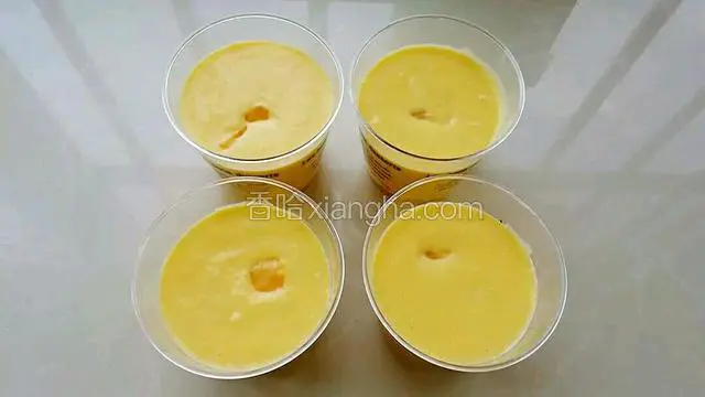 把奶油芒果糊均匀的倒入慕斯杯内，可以在每个杯子里放几粒芒果，放进冰箱冷藏定型。