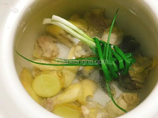 倒入适量清水，放入鸡、葱、姜片和料酒，大火煮沸后转小火炖一小时。