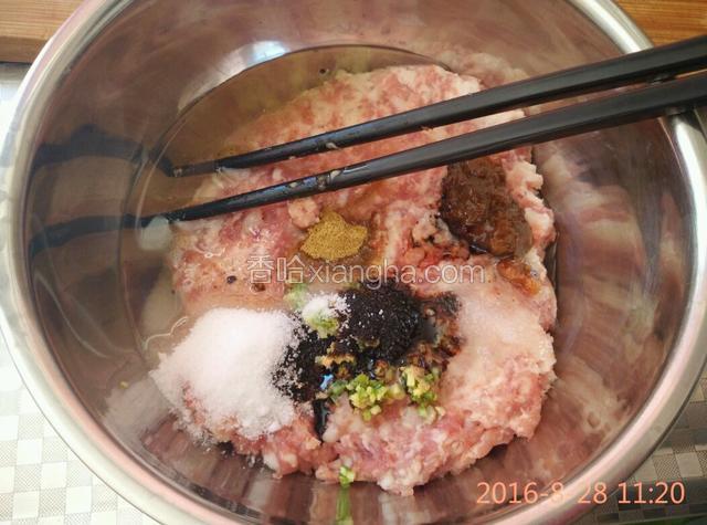 剁好的肉糜放入碗中，加入盐、油、葱姜末、十三香、酱油、豆瓣酱顺时针搅打上劲