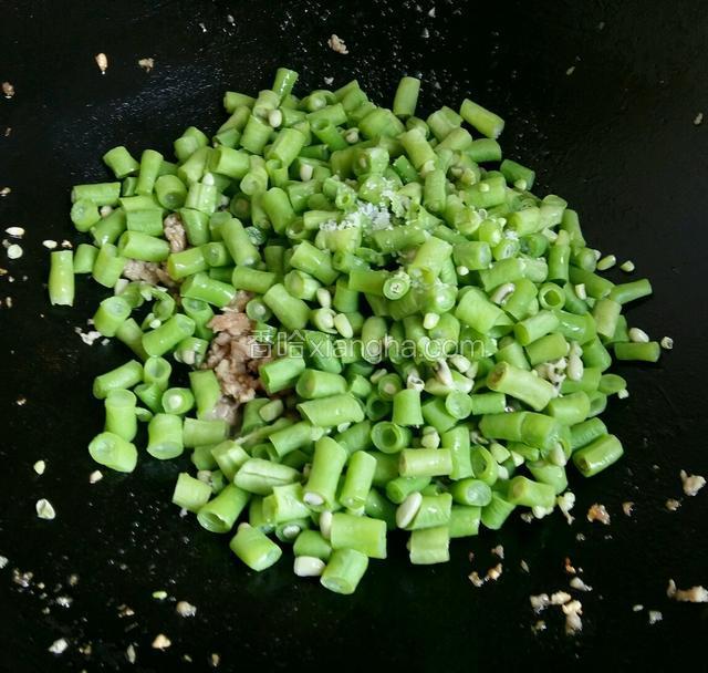 把焯过水的豆角倒进去，放少许盐。翻炒均匀就可以了。