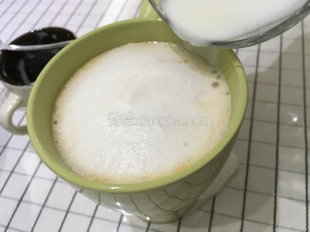 再将奶泡用勺子舀至马克杯。请忽略杯的颜色。我做了两杯，蓝色杯子最后的花花很丑！就换绿杯子的拍了。