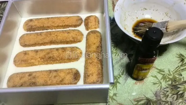 倒入一半的蛋糕糊震几下另外铺入手指饼干在全部倒入蛋糕糊放冰箱冷藏4个小时