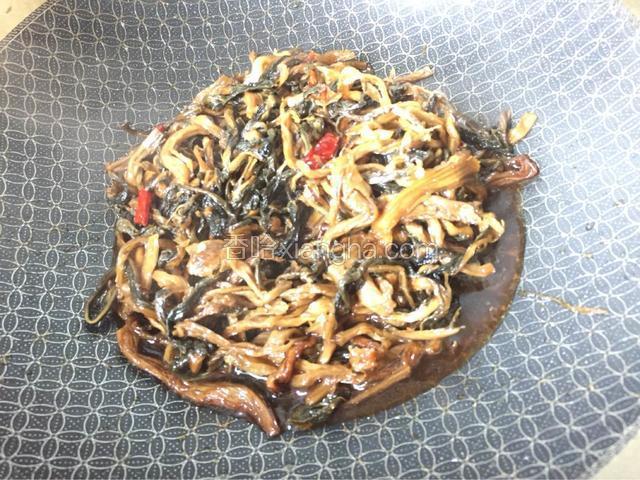 将洗好后的梅干菜倒入锅中，利用煎肉的余油，然后加点水，《不要太多了》加入少许，盐，，老抽，干辣椒，和少许冰糖调味，小火闷15分钟左右