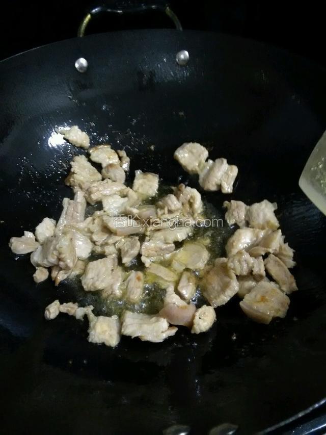 锅中留底油，放入猪肉炒至断生，放入白酒炒香
