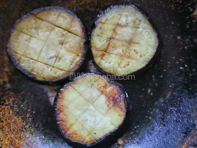 锅中放适量油，煎茄片至两面发黄盛出备用
