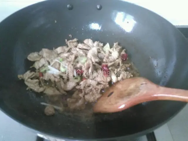 锅里倒油烧至五成热，下入腌制好的肉片炒至变色放入葱姜蒜和干辣角翻炒均匀。