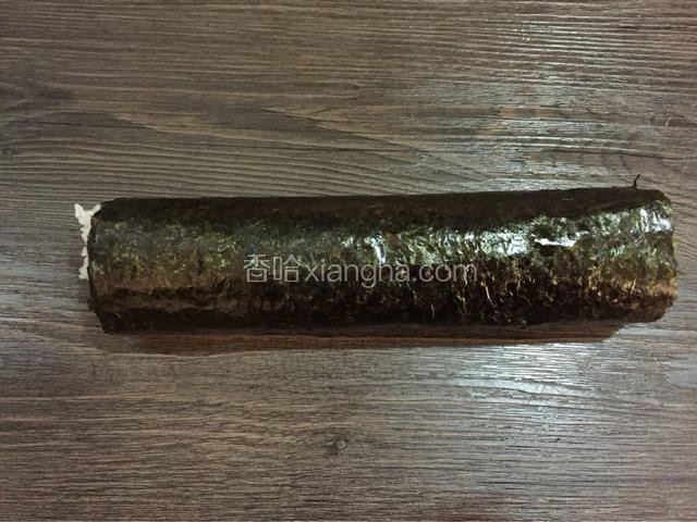 卷动寿司帘卷成卷，一边卷一边拉动寿司帘使其更紧避免散开