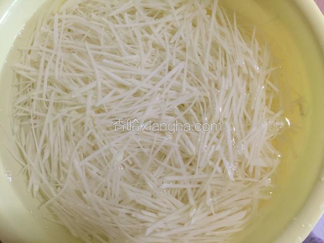 切好的土豆丝马上放入清水中防止氧化变黑。其它几个土豆依次切成丝。