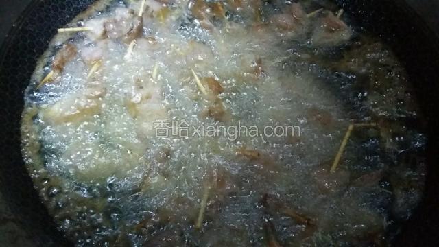 用筷子不婷翻动肉串，炸均匀。