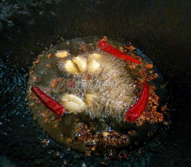 锅中热油，下大蒜，花椒，豆豉和干辣椒火锅底料小火炒出香味。