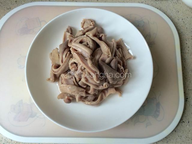 猪肚用面粉、盐反复揉搓洗净后煮熟，切成片状。