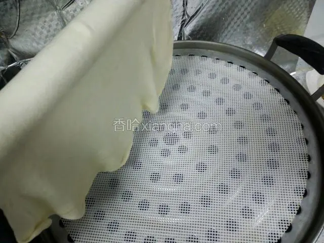 擀好一张饼搭在擀面杖上，转动擀面杖把饼铺在盖帘上