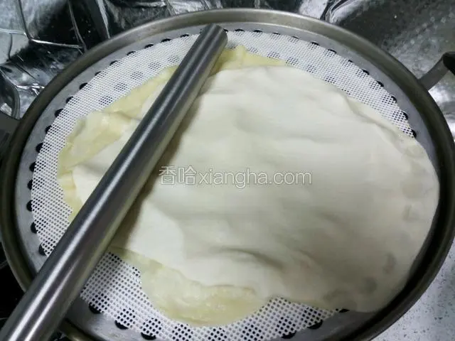 依次擀好薄饼铺在蒸屉上，一张摞一张