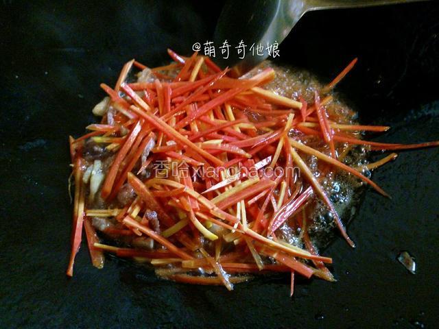 翻炒至肉变微黄后加入胡萝卜丝大火翻炒片刻至软。