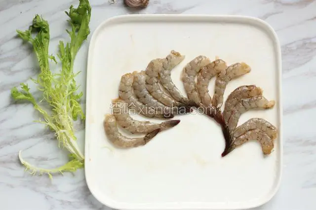 将虾去头去壳，留尾部一节，沿虾背剪开至尾部一节，去掉虾线。